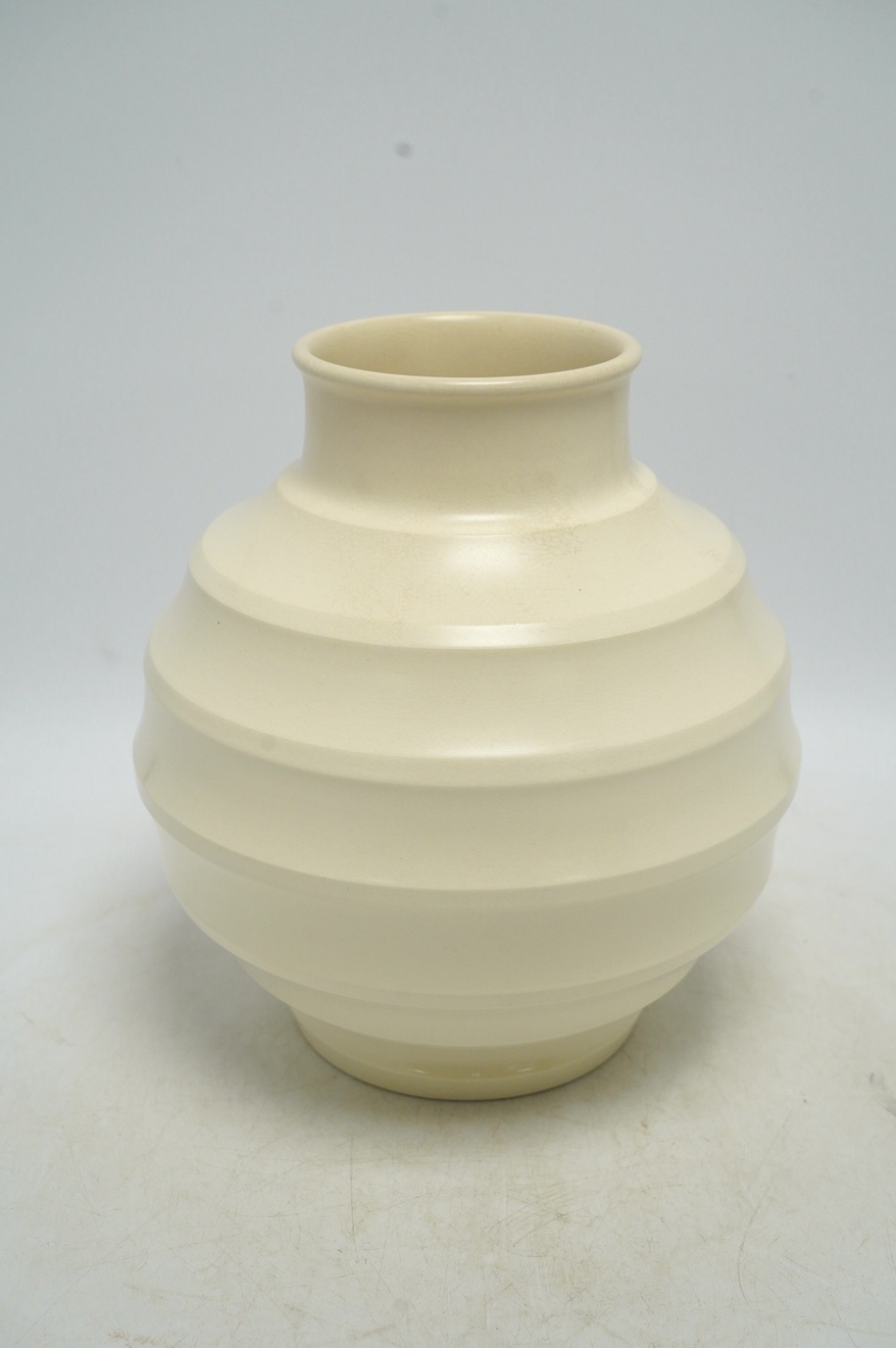Keith Murray for Wedgwood, a cream glazed ribbed globular vase, 23cm. Condition - fair, star crack visible to base from interior